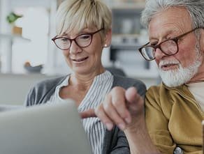 A couple pointing at a laptop screen